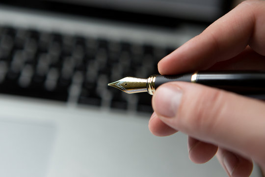 Termination letter lying on a laptop computer keyboard with a pen waiting for acknowledgement or signature