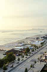 Beach of Black Sea from Mamaia, Romania with golden sands, sun umbrellas, sunbeds, blue clear water, bars and hotels