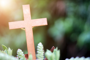 Stone Cross on nature green bokeh background.The Cross symbol of christian and Jesus Christ.