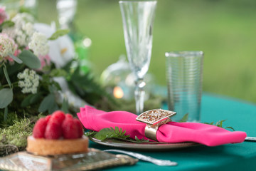 table setting. Wedding decor in the magic forest for a loving couple. Pink and green colors. Raspberry dessert.