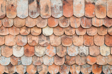 Close-up of old and weathered red roof tiles texture background.