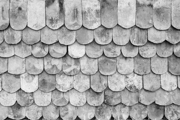 Close-up of old and weathered roof tiles texture background in black and white.