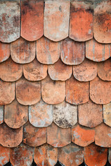 Close-up of old and weathered red roof tiles texture background with vignette.