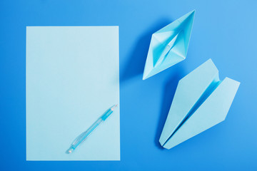 paper boat and aircraft on blue paper background