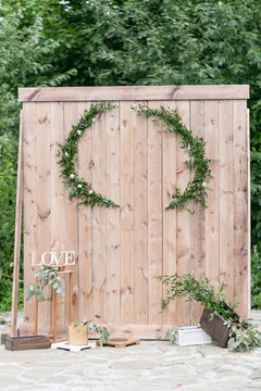 Old Wall Or Fence Of Wooden Boards. Summer Day In The Park. Use For Background. Wedding Photo Zone With Rustic Decorations