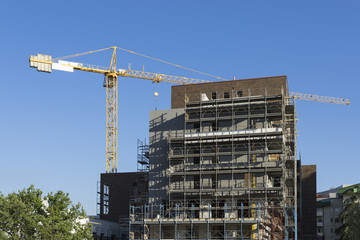 scaffolding housing construction with yellow tower crane