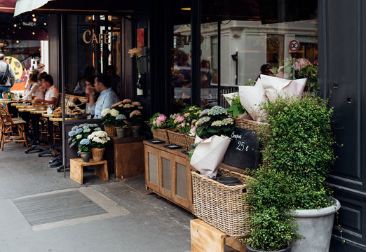 Cozy street with flower shop and table of  in Paris, France