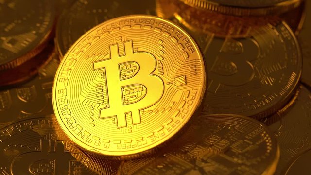 Bitcoin coin is glowed with golden light and gradually fades. Macro shot. 4K looped video.