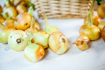assorted fresh onions on a wooden table. wallpaper for grocery shopping and cooking food concept