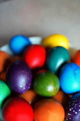 Fototapeta na wymiar Colorful boiled Easter eggs in white plate on grey background.