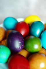 Fototapeta na wymiar Colorful boiled Easter eggs in white plate on grey background.