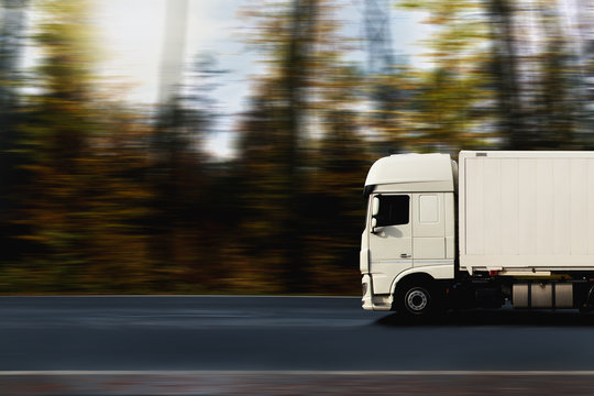 Lkw f&auml;hrt schnell auf einer Stra&szlig;e durch den Wald