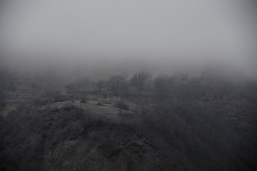 Fototapeta premium Panorama of the foggy winter landscape in the mountains with snow and rocks, Azerbaijan, Lahic, Big Caucasus