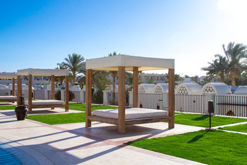 Fototapeta na wymiar Lovely close-up of a beach sunbath shelter with a luxurious spectacular sunny landscape