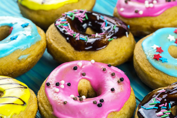 Bright and colorful homemade donuts on a wooden background