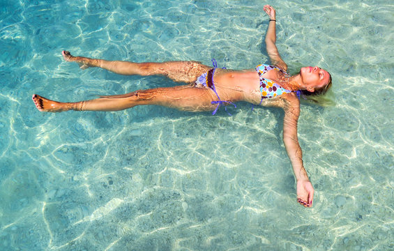 Beautiful girl swimming on back in the sea