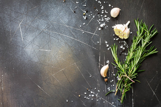 Spices and herbs on a dark stone or slate table. Ingredients for cooking. Food background. Copy space, top view flat lay background.
