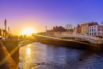 Naklejka premium Most Ha'penny nad rzeką Liffey o zachodzie słońca, Dublin Irlandia, marzec 2018 r