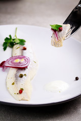 Herring fillet with red onion and cream.