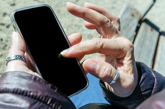 Detailed close view of woman hands using her mobile phone