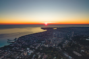Fototapeta na wymiar Dramatic sunset over the city of Sukhumi .