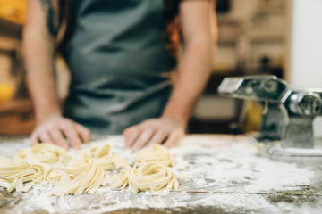 Chef against kitchen table with homemade pasta