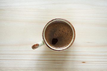 Coffee Cup on wooden table with top view.