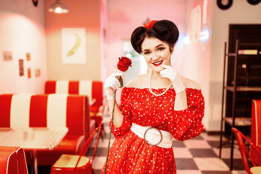 Sexy pin up woman with make-up holds red rose