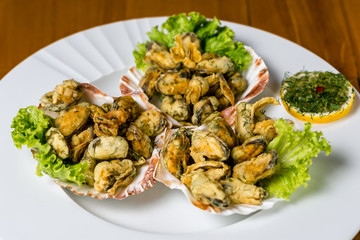 Seafood. fired Mussels appetizer with  lemon served on Clam shells.Top view. Wooden background.