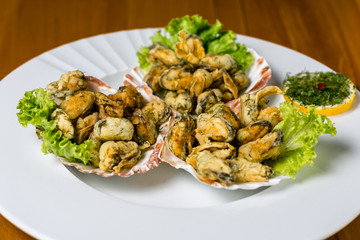 Seafood. fired Mussels appetizer with  lemon served on Clam shells.Top view. Wooden background.