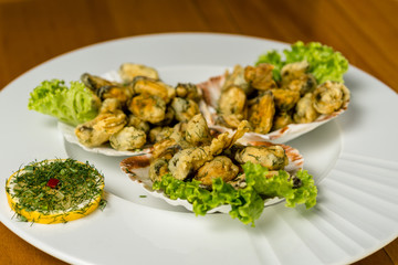 Seafood. fired Mussels appetizer with  lemon served on Clam shells.Top view. Wooden background.