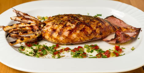 Grilled whole squid on a BBQ with Greek Spice. Top view. Wooden background. 