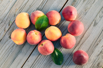 Fresh peaches fruits with leaves  on wooden rustic background.