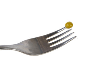 a green pea is punctured on a fork on a white background
