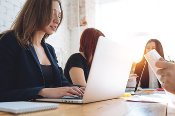 Young business woman work on modern laptop in coworking loft studio. Team of coworkers meeting in office. Team creative designer making new start up