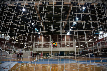 Handball concept. Goal post nets from behind view. Blurred court, athletes and electronic...