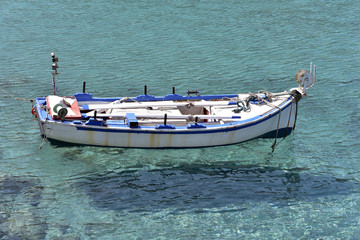 Traditional fishing boat in the sea near Adamantas village, Milos island, Greece