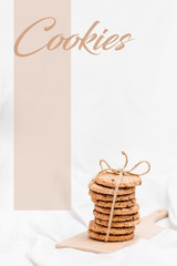 Photo of a sweet homemade cookies wrapped with rope on a wooden board and white background with styled quote Cookies