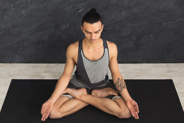 Naklejka premium Young man practicing yoga, relax meditation pose