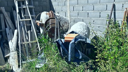 Maquinas de hormigón viejas abandonadas entre otras herramientas de construcción