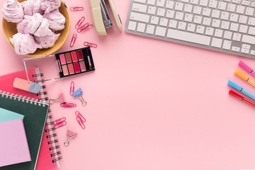 Working space with keyboard on pink background