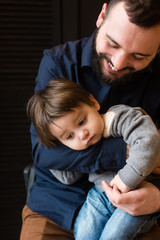 Small kid and his father at black