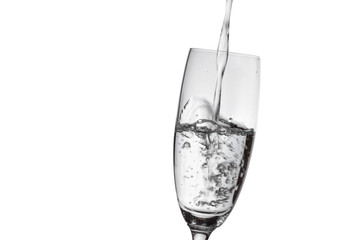 Pouring water into the glass isolated on white background.