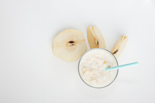 Healthy eating,diet smoothie drink is made from natural  pear and banana with a straw on a white wooden background