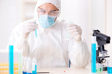 Young chemist student working in lab on chemicals