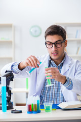 Young chemist student working in lab on chemicals