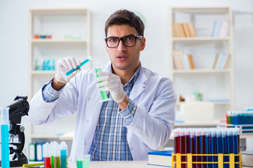 Young chemist student working in lab on chemicals