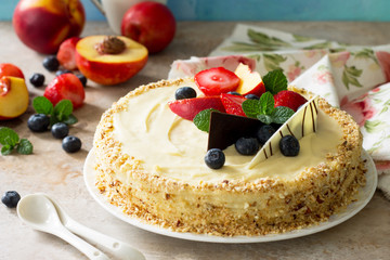 Delicious dessert cake with fresh berries and whipped cream, sweet delicious holiday cake with blueberries and strawberries on stone background.
