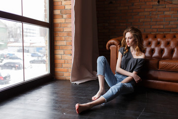 Young woman looking in window in loft apartment