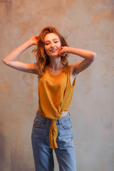 Portrait of beautiful young woman touching her hair. Redhair long hairstyle